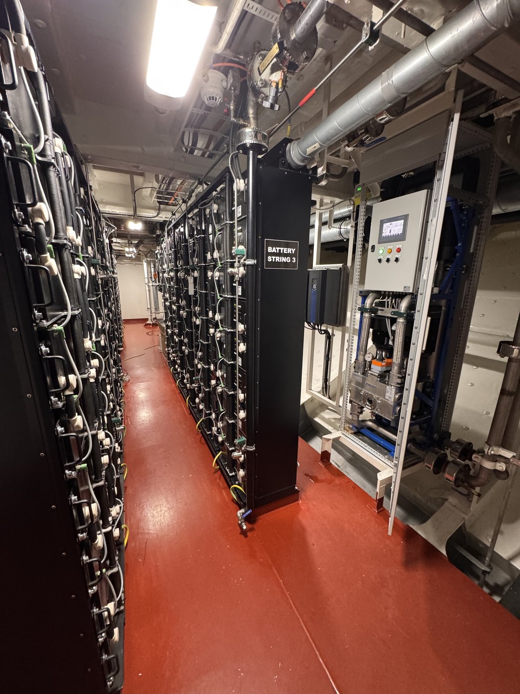Marine battery room with battery racks and supporting equipment.